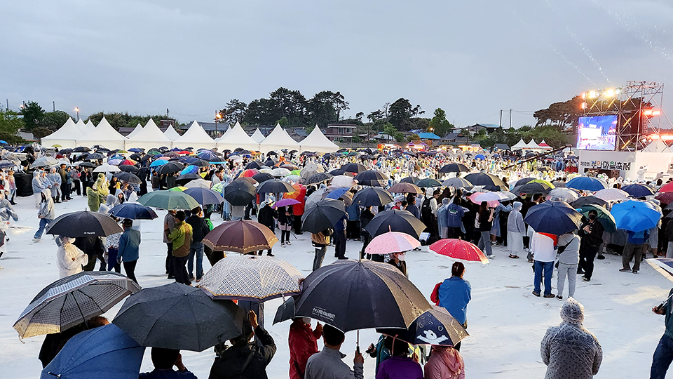 지난 4일 부안마실축제 개막식. 비가 내리면서 축제장 방문객들이 비옷을 입거나 우산을 쓰고 있다.
