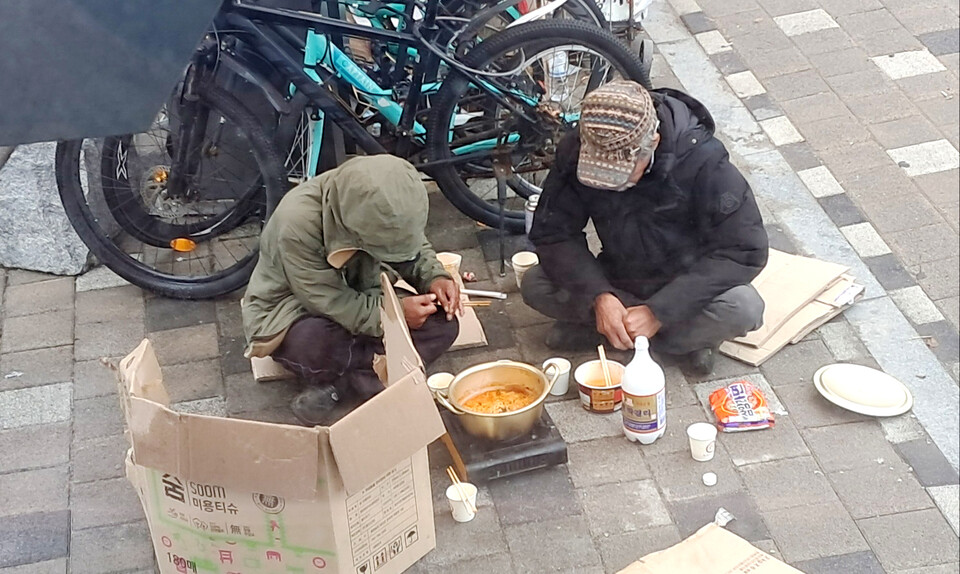 부안농어촌버스 주변. 노숙자처럼 보이는 두 사람이 휴대용 가스버너에 라면을 끓여 술과 함께 먹고 있다. 사진 / 주민제공.